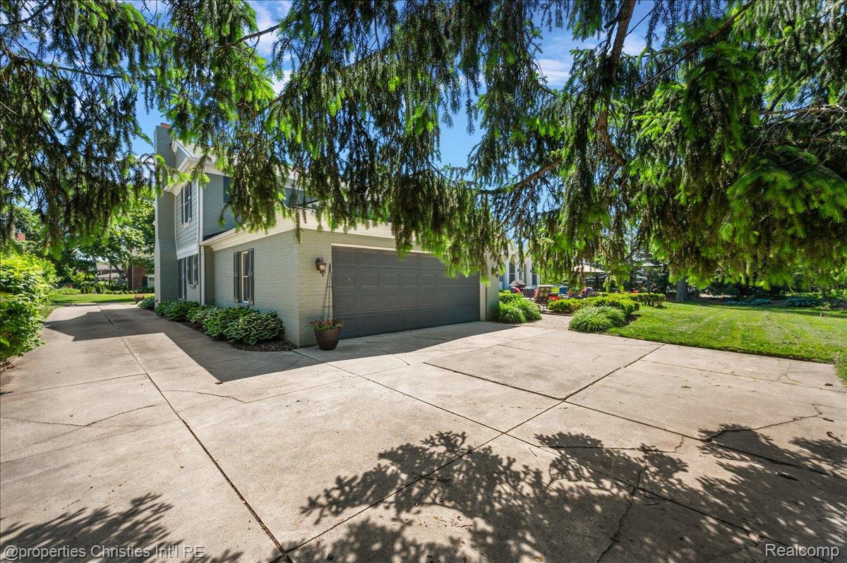 135 Clifton Road Bloomfield Hills, MI 48301 - Photo 66 of 77 Spacious concrete driveway featuring a two-car garage with a dark panel door