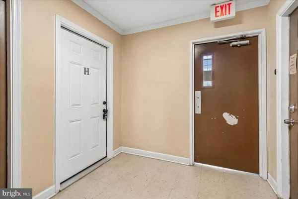 an empty room with fan and entrance