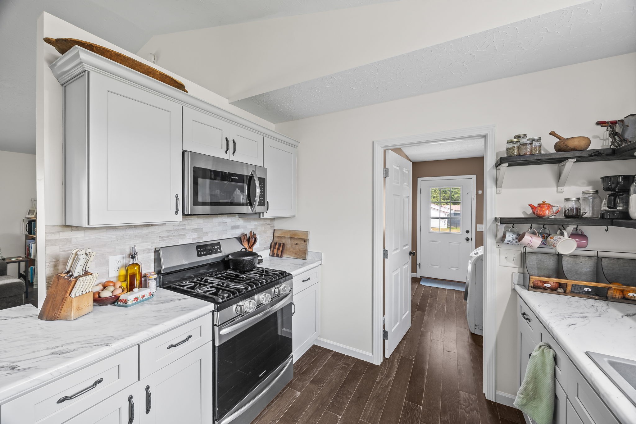 13723 Old Kentucky Road Walling, TN 38587 - Photo 7 of 34 a kitchen with stainless steel appliances granite countertop a stove top oven a sink dishwasher and a refrigerator with wooden floor