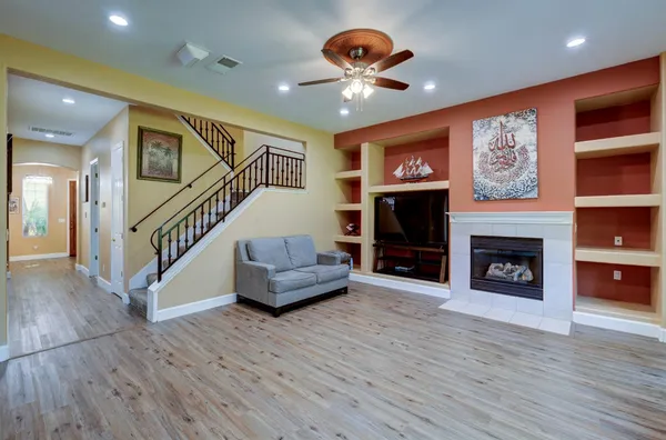 a view of a livingroom with an empty kitchen and a fireplace