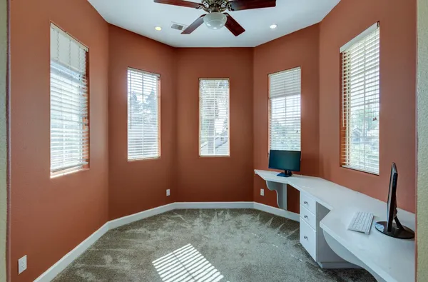 a workspace with hardwood floor and windows