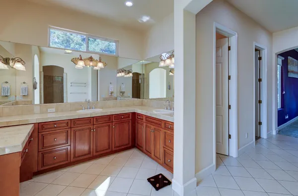 a spacious bathroom with a granite countertop sink mirror and cabinets