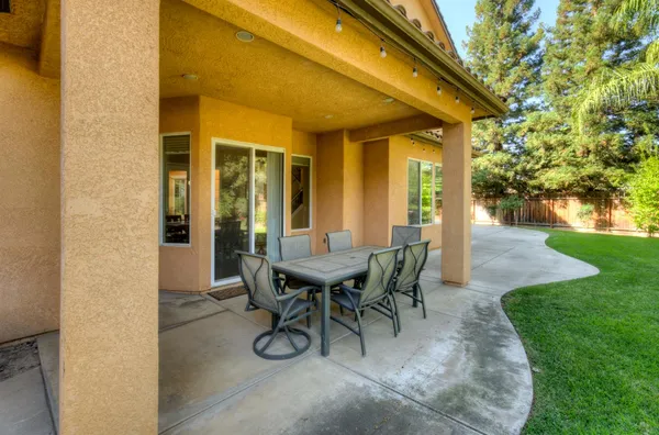 a view of a patio with table and chairs and garden