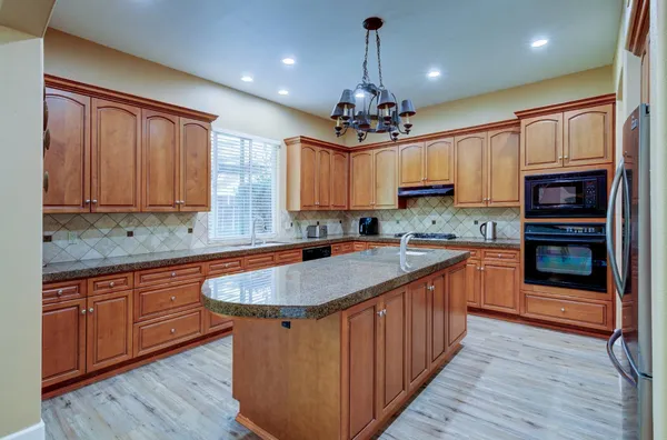 a kitchen with stainless steel appliances granite countertop wooden cabinets a sink and dishwasher