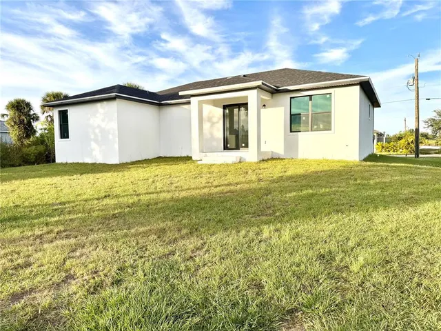 a backyard of a house with yard and outdoor seating