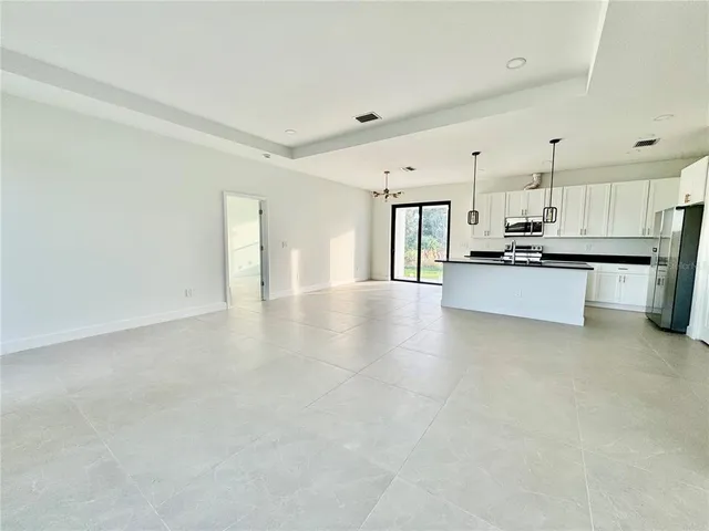 a view of a kitchen with a sink wooden cabinets and stainless steel appliances