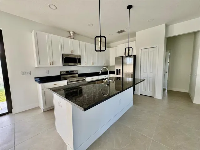 a kitchen with stainless steel appliances granite countertop a stove a refrigerator and a sink