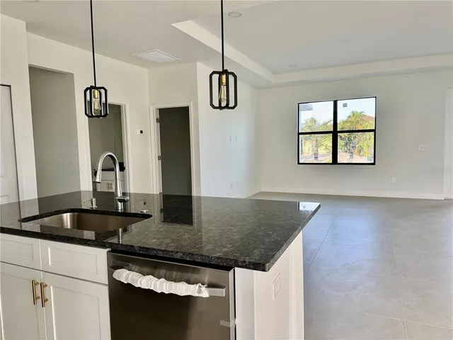 a kitchen with stainless steel appliances granite countertop a sink a refrigerator and a granite counter tops