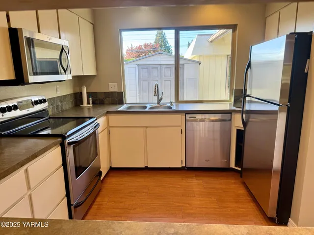 a kitchen with stainless steel appliances granite countertop a stove a sink and a microwave