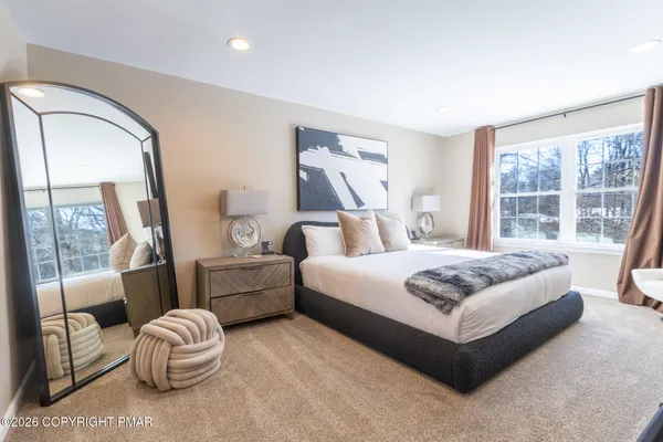 a bedroom with a bed and a large mirror