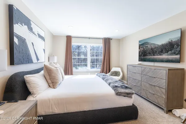 a bedroom with a bed and a painting on the wall