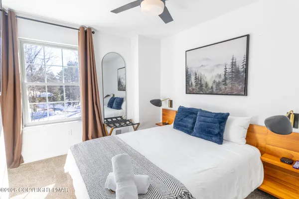 a bedroom with a bed and a painting on the wall