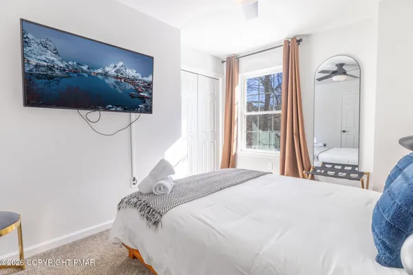 a bedroom with a bed and a painting on the wall