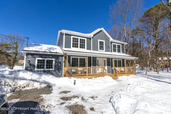 a view of a house with a yard covered with snow in the background