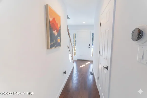 a view of a hallway with wooden floor and staircase