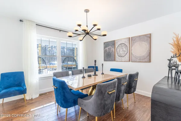a dining room with furniture a chandelier and wooden floor