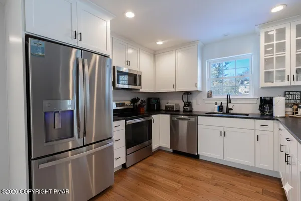 a kitchen with stainless steel appliances a refrigerator sink and microwave