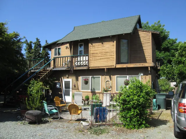 a view of multiple house with large windows and potted plants