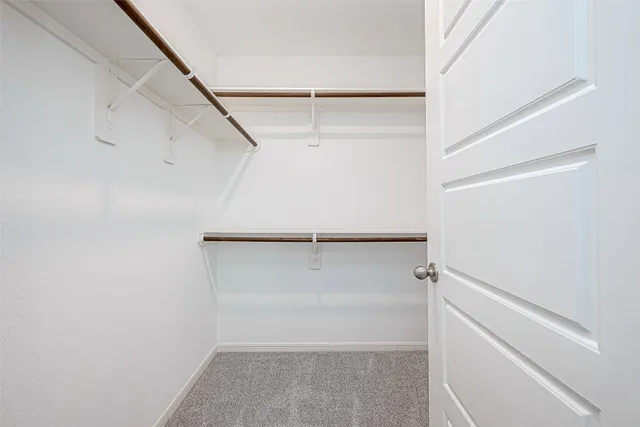 a view of walk in closet with empty racks