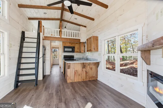 a view of a livingroom with wooden floor and a fireplace