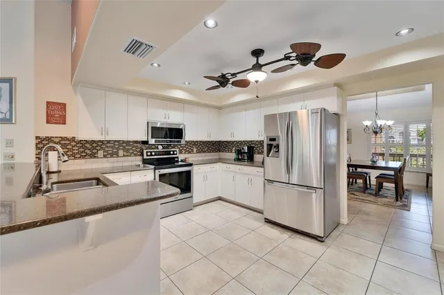 a kitchen with stainless steel appliances granite countertop a refrigerator sink and cabinets