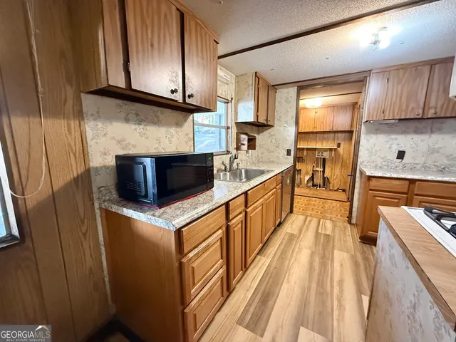 a kitchen with granite countertop a sink stove and refrigerator