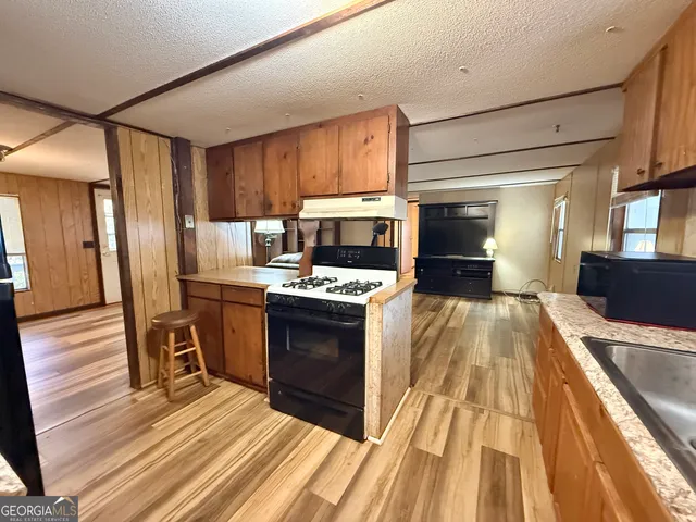 a kitchen with stainless steel appliances granite countertop a refrigerator and a stove top oven