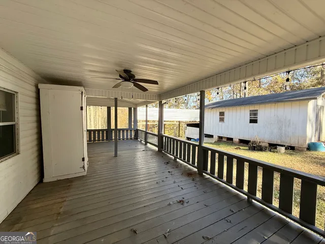 a view of a livingroom with wooden floor and a ceiling fan