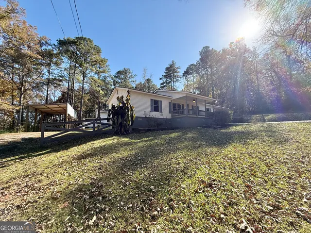 a view of a house with a yard and wooden fence
