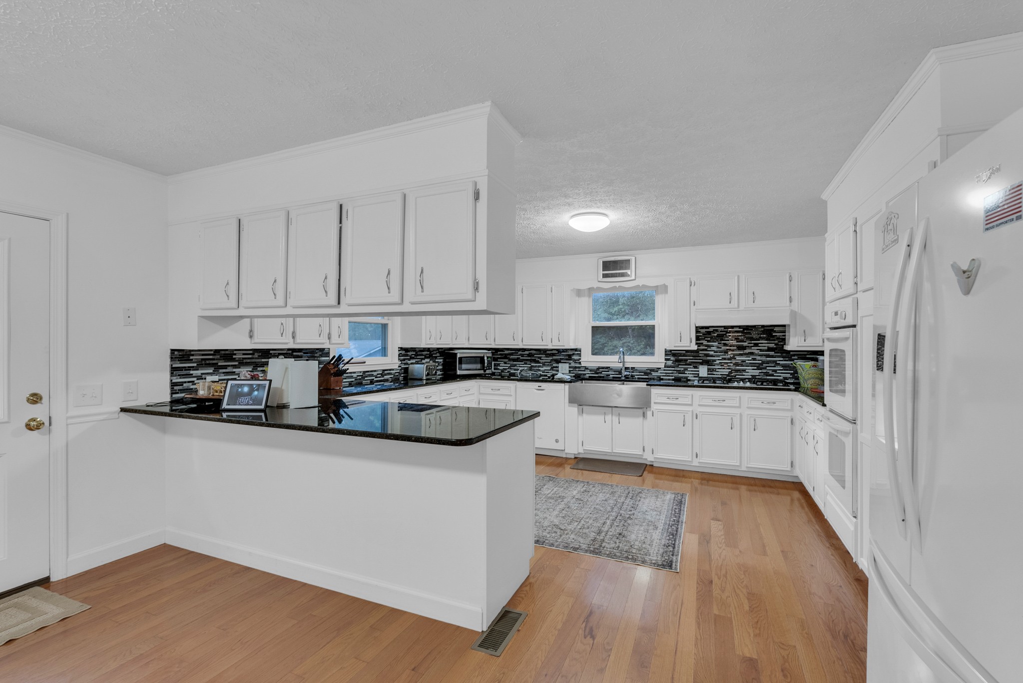 1389 Coconut Ridge Road Smithville, TN 37166 - Photo 14 of 39 a kitchen with stainless steel appliances white cabinets and wooden floor