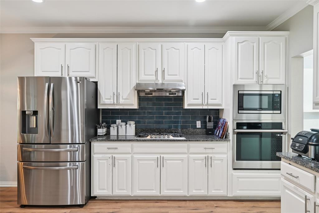 1321 Shell Beach Drive Little Elm, TX 75068 - Photo 13 of 40 a kitchen with stainless steel appliances granite countertop a refrigerator and cabinets