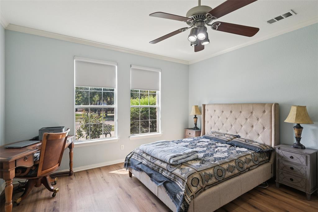 1321 Shell Beach Drive Little Elm, TX 75068 - Photo 16 of 40 a bedroom with a large bed and a chandelier