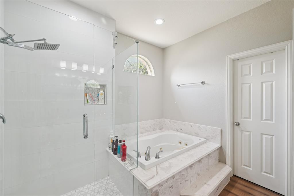 1321 Shell Beach Drive Little Elm, TX 75068 - Photo 19 of 40 a bathroom with a tub shower and mirror