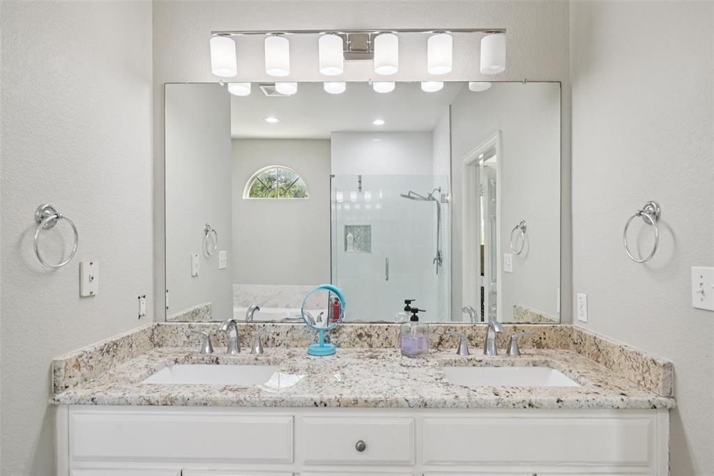 1321 Shell Beach Drive Little Elm, TX 75068 - Photo 21 of 40 a bathroom with a granite countertop double vanity sink and a mirror