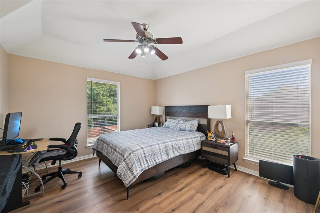 1321 Shell Beach Drive Little Elm, TX 75068 - Photo 27 of 40 a bedroom with a bed a desk and chair with wooden floor