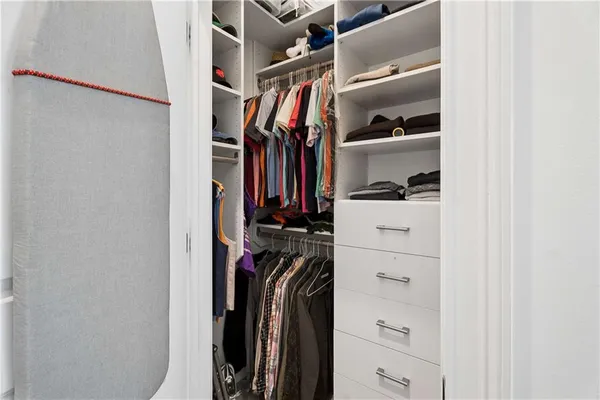 a view of walk in closet with clothes and shoes