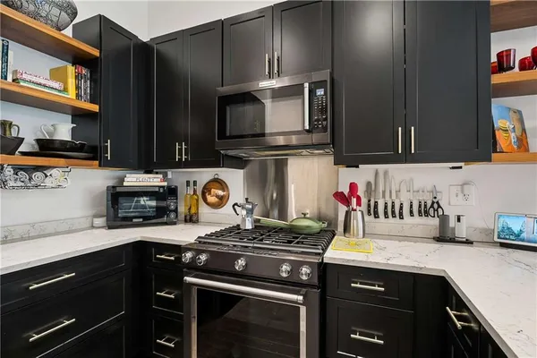a kitchen with stainless steel appliances granite countertop a stove and a microwave