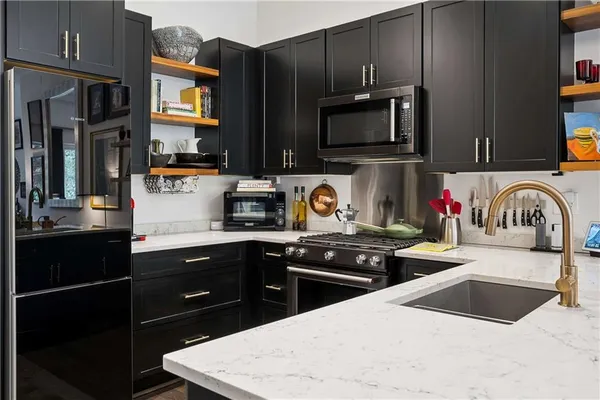 a kitchen with stainless steel appliances a stove microwave and sink