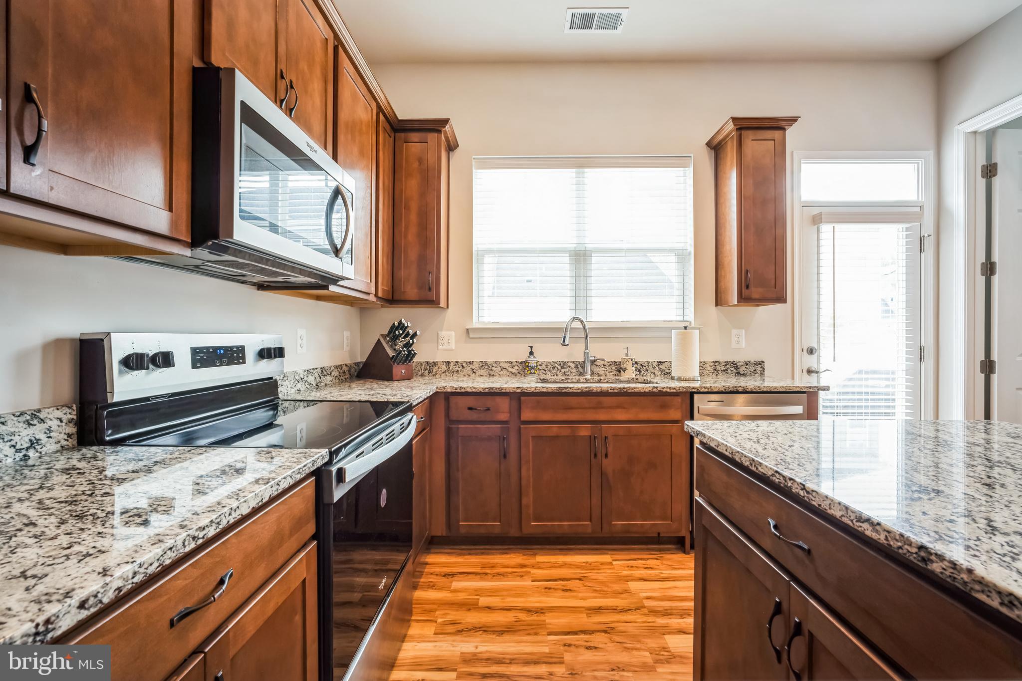 9348 Crestview Rdg Drive Bristow, VA 20136 - Photo 12 of 29 a kitchen with stainless steel appliances granite countertop a stove a sink and a microwave