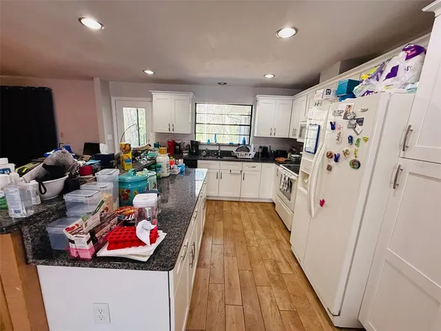 a kitchen with sink refrigerator and wooden floor