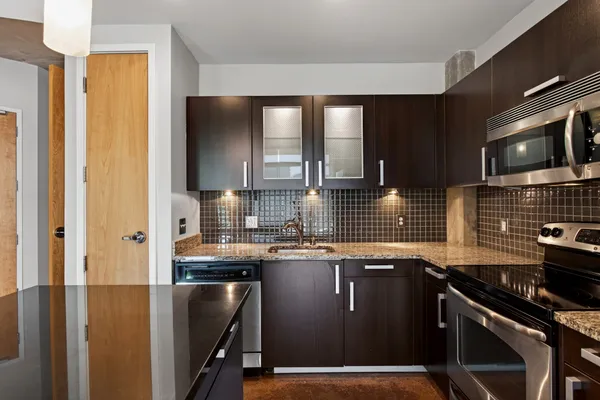 a kitchen with stainless steel appliances granite countertop a sink stove and cabinets