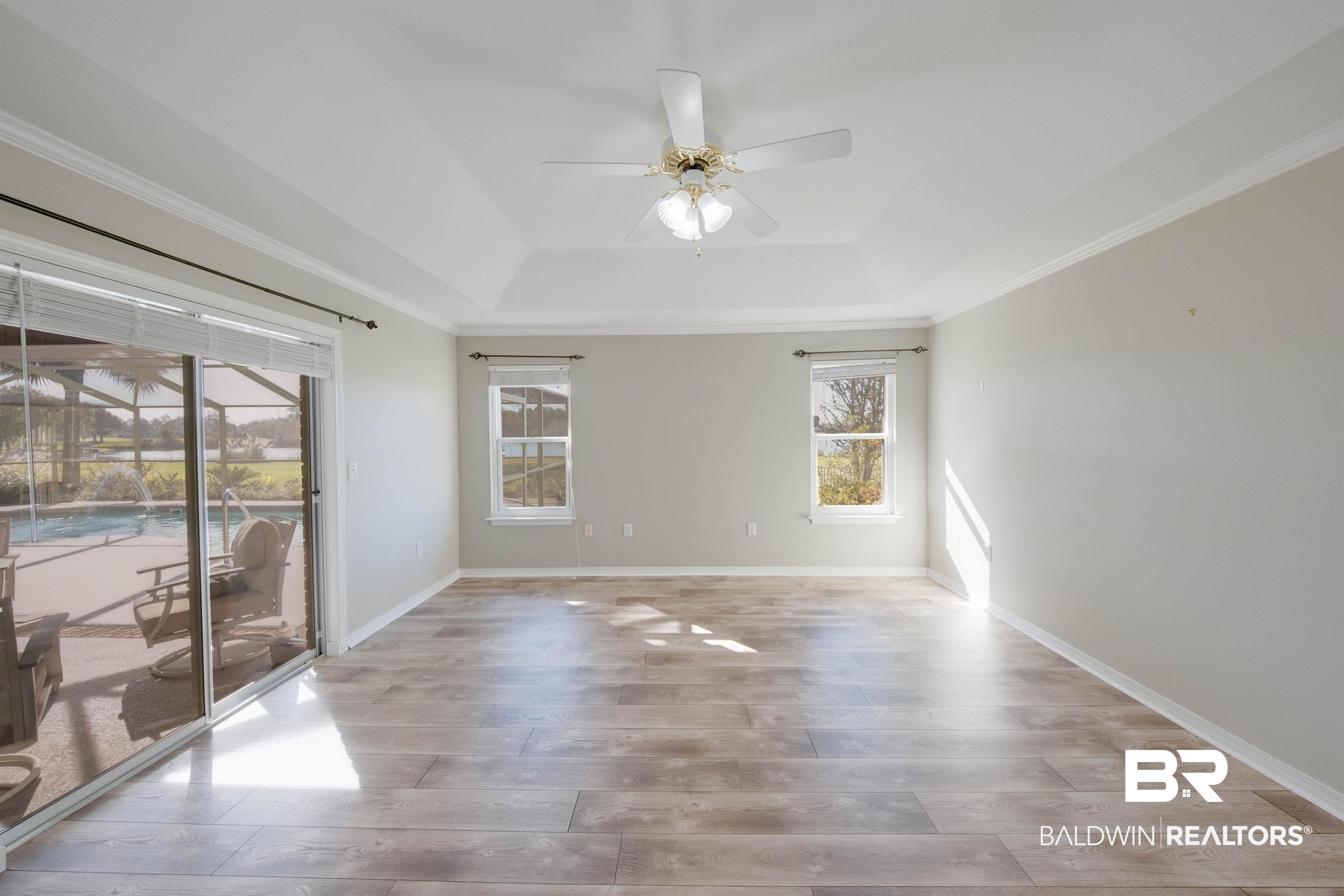 9462 Lakeview Drive Foley, AL 36535 - Photo 27 of 50 Master bedroom with ornamental molding, a tray ceiling, light hardwood / wood-style floors, and ceiling fan with view