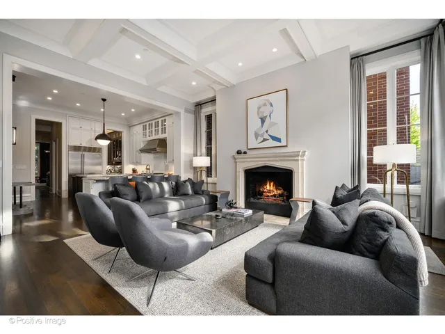 a living room with furniture a large window and a fireplace