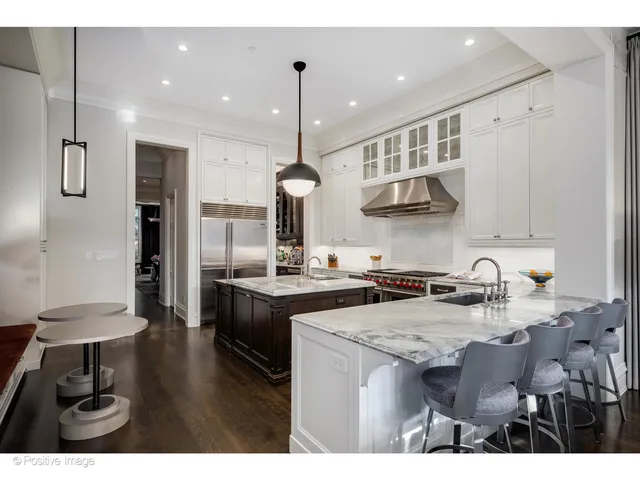 a kitchen with kitchen island granite countertop a sink a counter space and stainless steel appliances