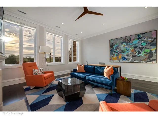 a living room with furniture a desk and chair with wooden floor