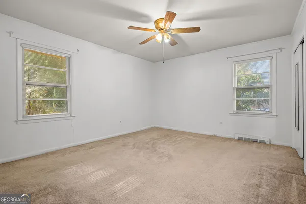 an empty room with closet and a chandelier fan