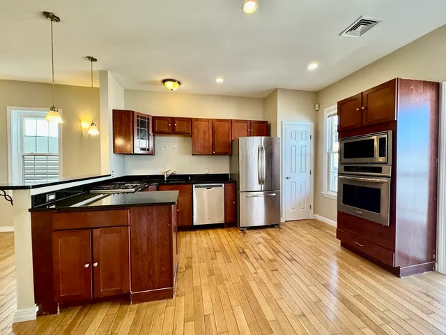 a kitchen with stainless steel appliances a stove a refrigerator and a sink