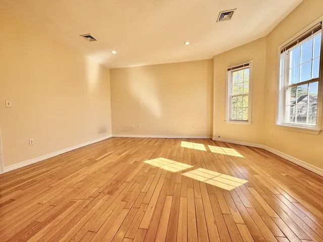 a view of a room with wooden floor and natural light