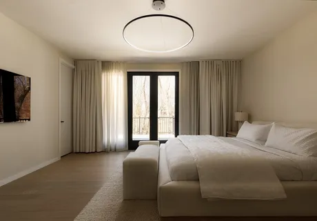a bedroom with a large bed and a chandelier