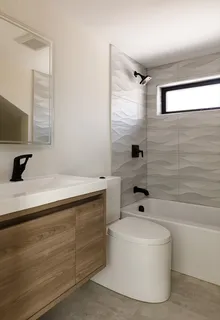 a bathroom with a bathtub a sink and a mirror